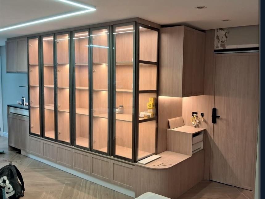 Sala com cristaleira planejada de vidro e iluminação interna